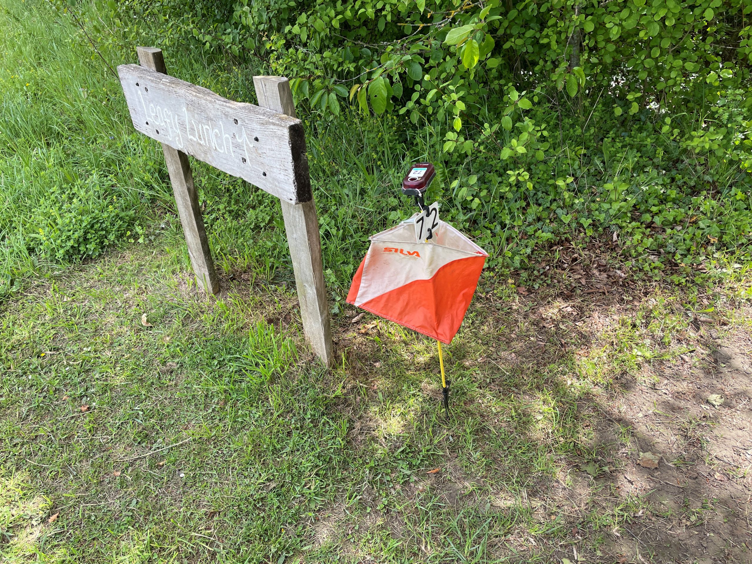 wooden sign next to orienteering marker