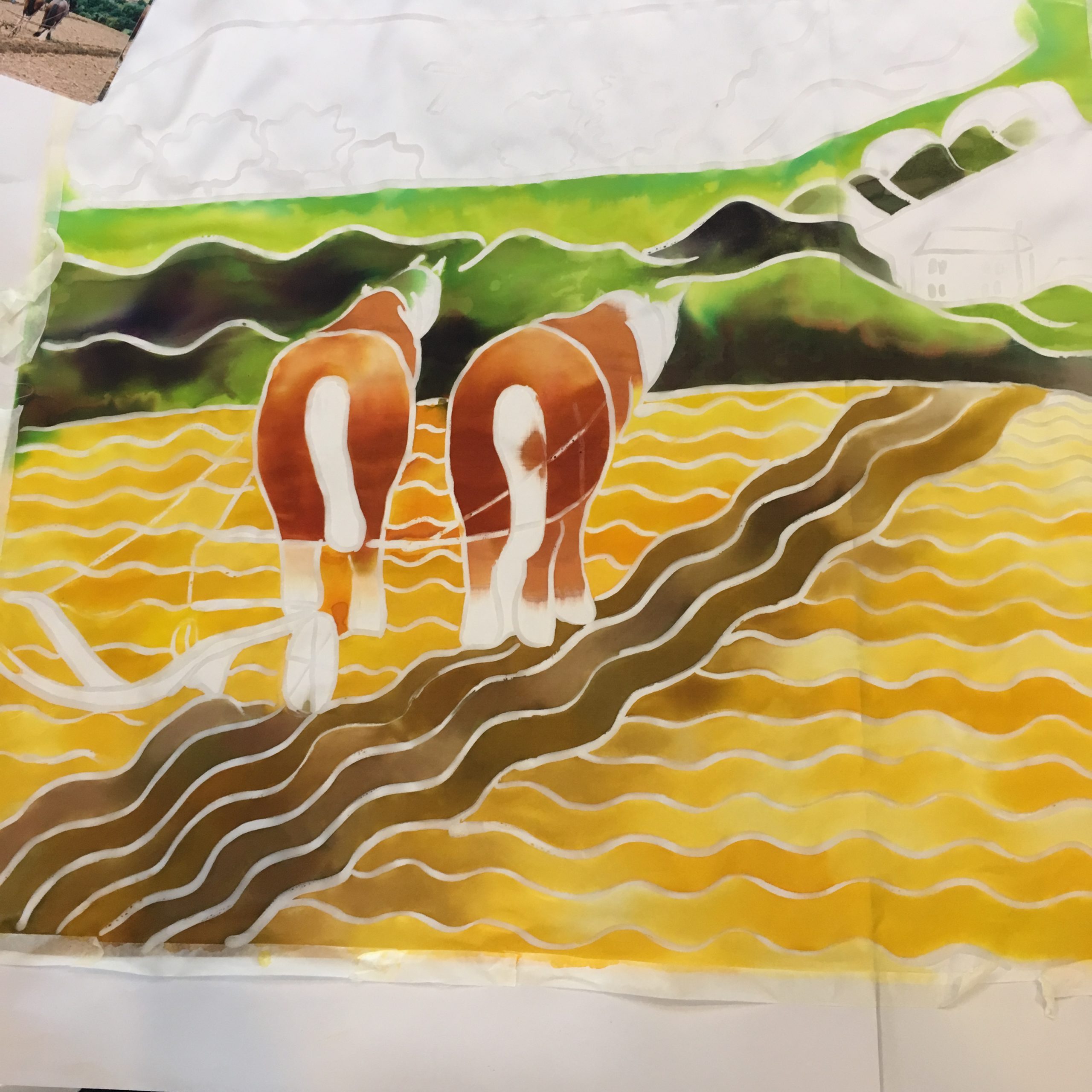 Colourful silk painting of horses walking across field