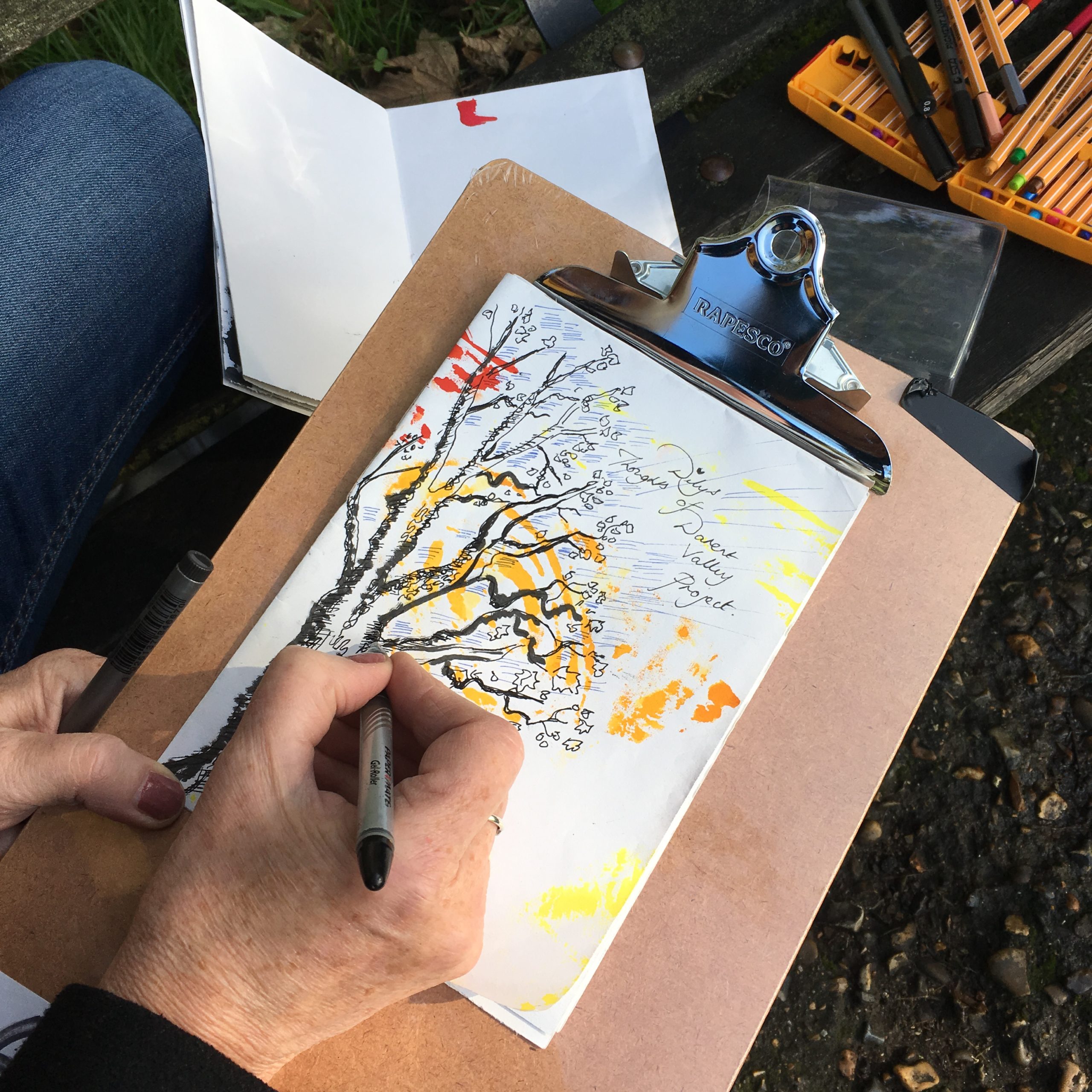 Clipboard with hand painting a tree on paper