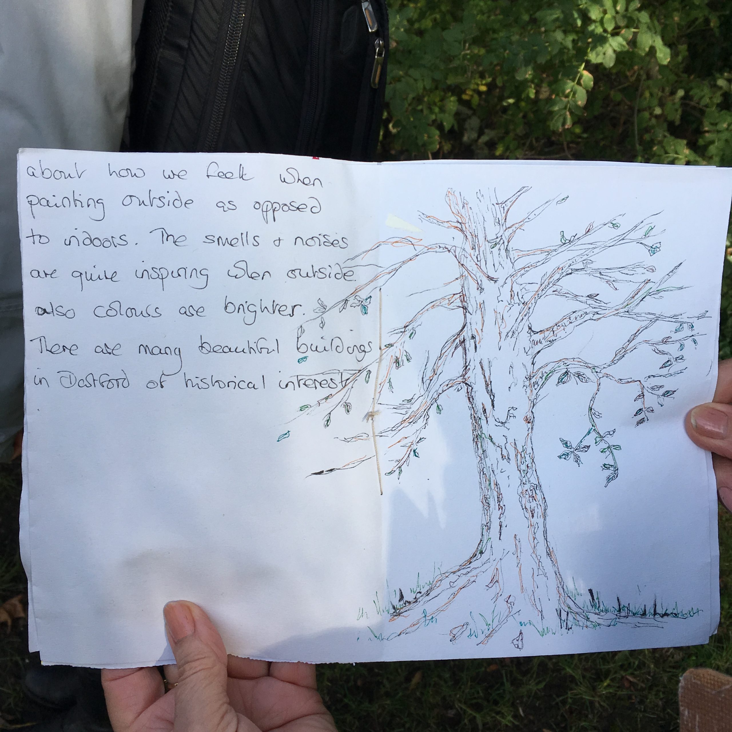 Workbook with writing and a sketch of a tree