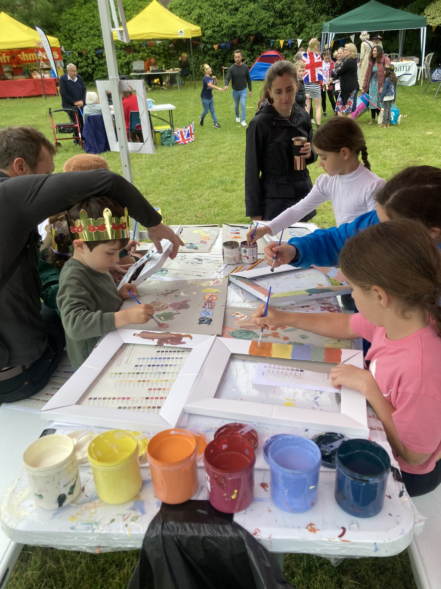 Children and adults painting frames on a table